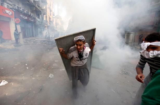 protestor fleeing tear gas in Tahrir Square