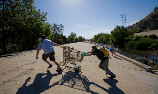 people hauling trash out of LA River