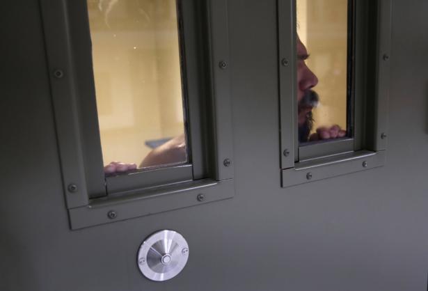 prisoner loooking out of prison door window