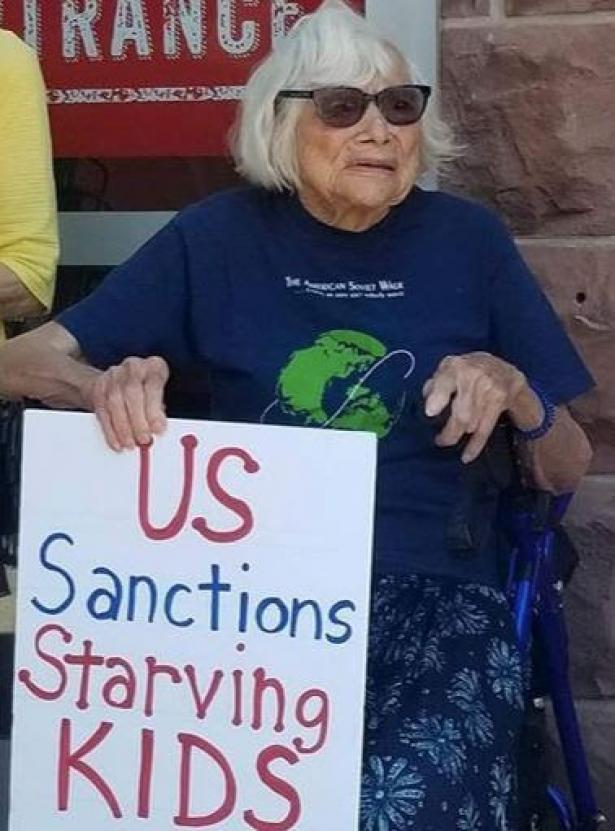 older woman holding protest sign