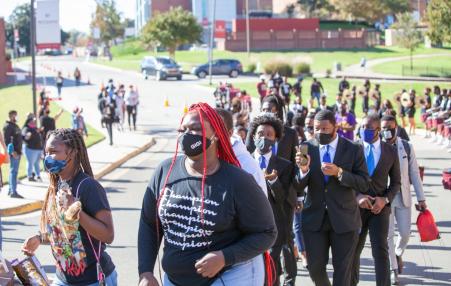 students of color marching to vote at polls