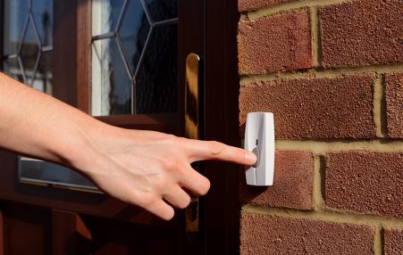 hand ringing doorbell