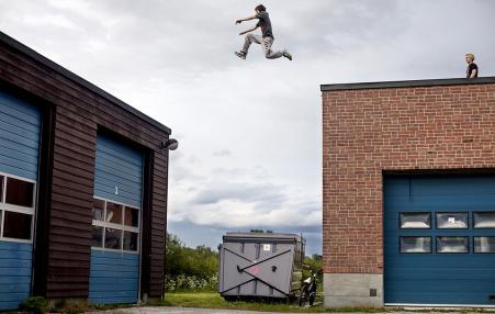 Teenagers leaps between buildings